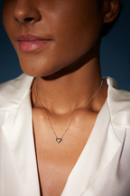 Model trägt eine Diamant-Herzkette aus 18K Gelbgold mit drei runden Labordiamanten und insgesamt 0,13 ct im warmen Sonnenlicht.