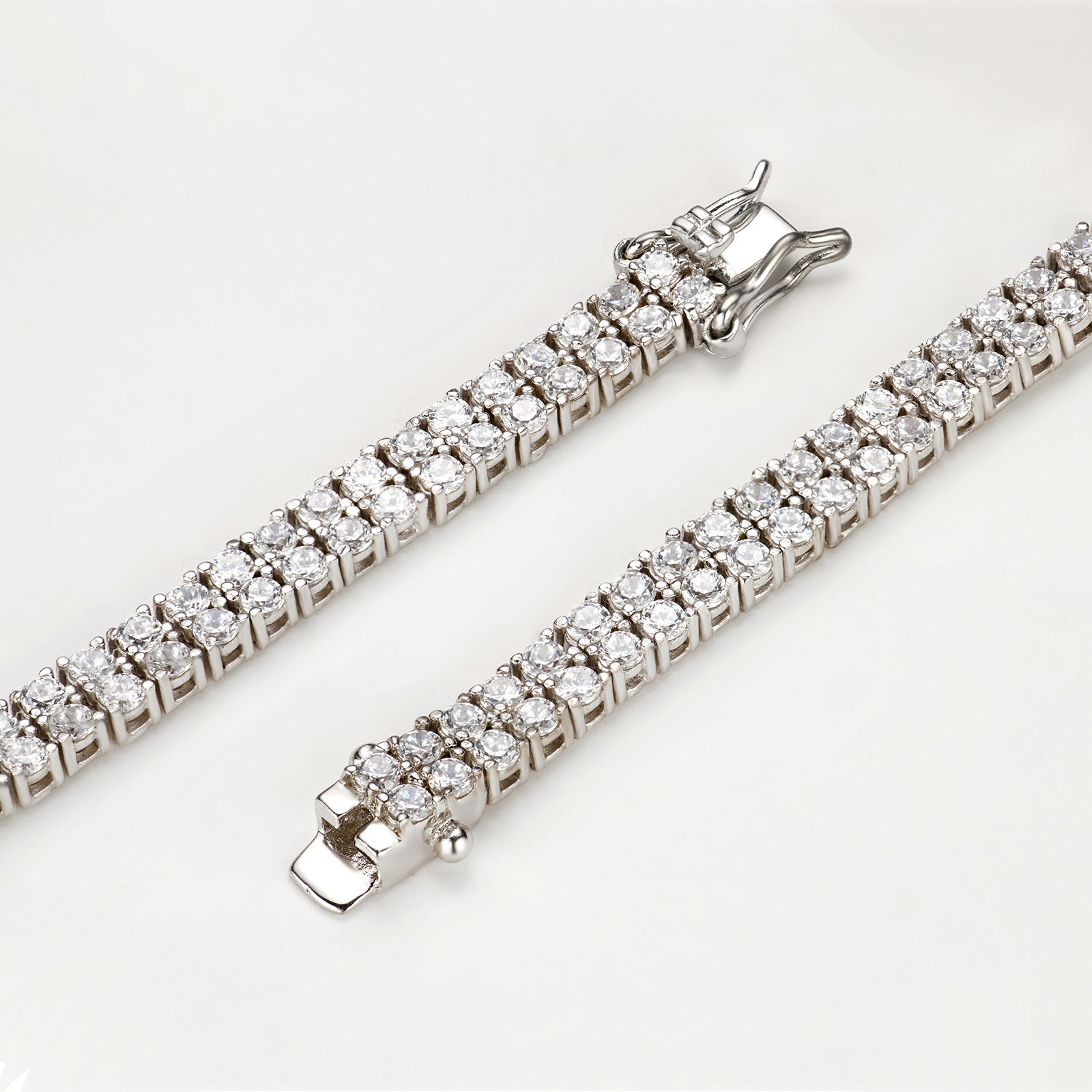 Detailaufnahme eines zweireihigen Tennisarmbands aus 18K Gold mit Labordiamanten und Sicherheitsverschluss.