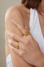 Model trägt einen Drei-Stein-Verlobungsring aus 18K Gold mit 3,50 ct Labordiamanten sowie einen Fancy Yellow Statement-Ring.