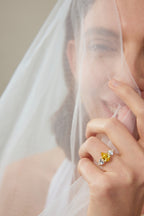 Model trägt einen Drei-Stein-Verlobungsring aus 18K Gold mit 3,50 ct Labordiamanten, Fancy Yellow Mittelstein und zwei weißen Seitensteinen.