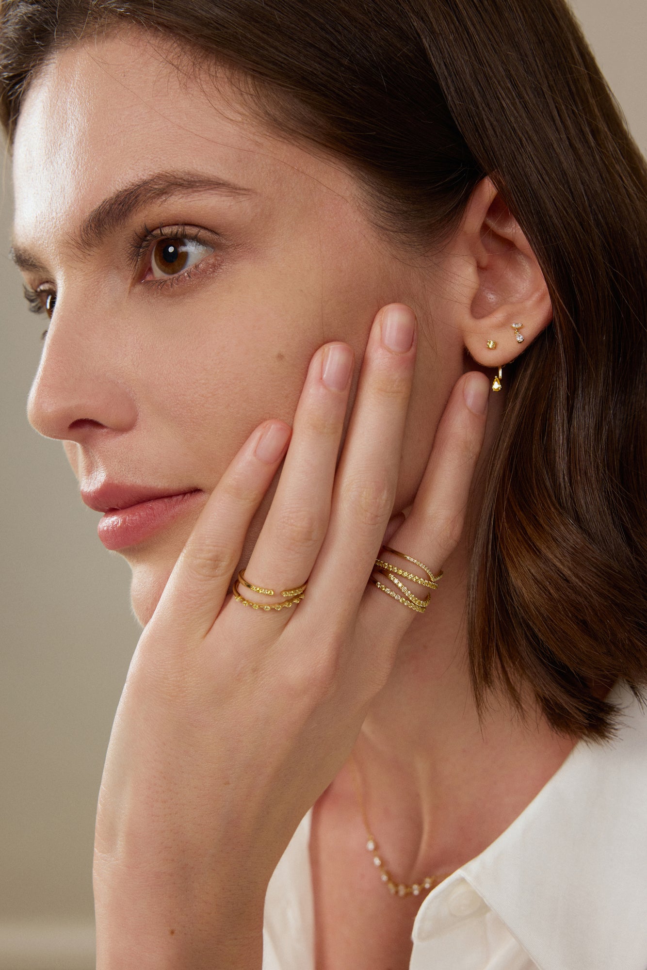 Model trägt filigrane Fancy Yellow Diamant-Ohrhänger aus 18K Gold mit runden und tropfenförmigen Labordiamanten sowie passende Ringe