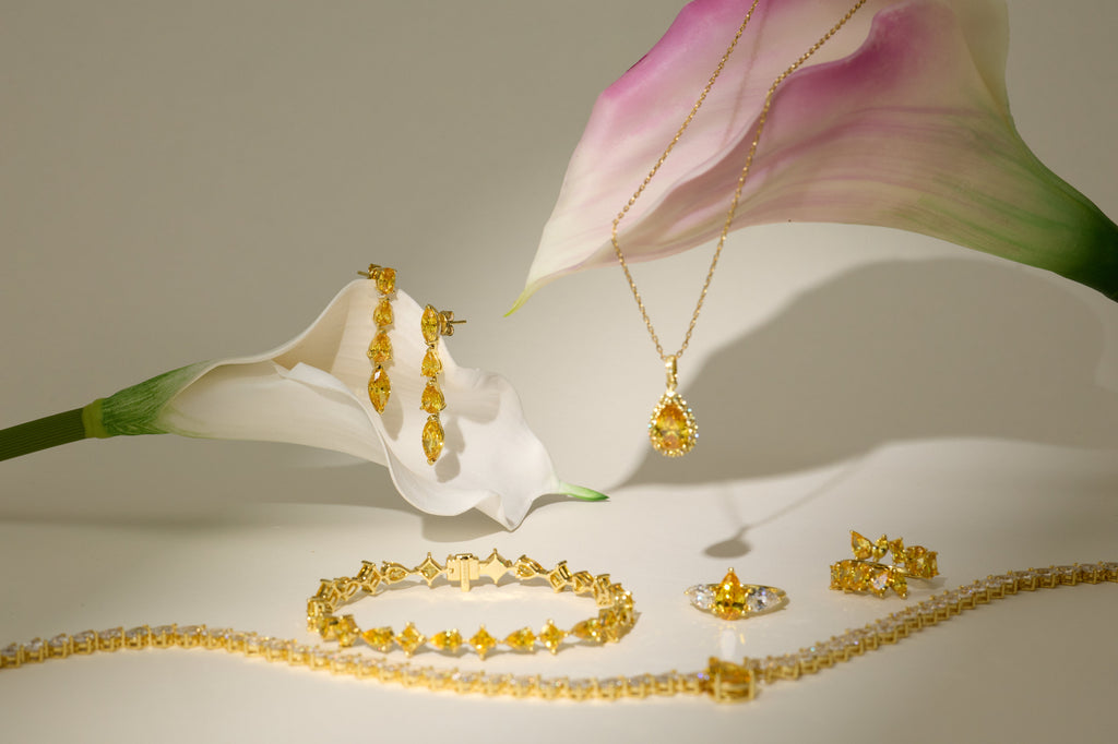 Fancy Yellow Diamant-Ohrhänger aus 18K Gold mit 5,50 ct Labordiamanten in einem eleganten Schmuckstillleben mit Collier, Ringen und Armbändern