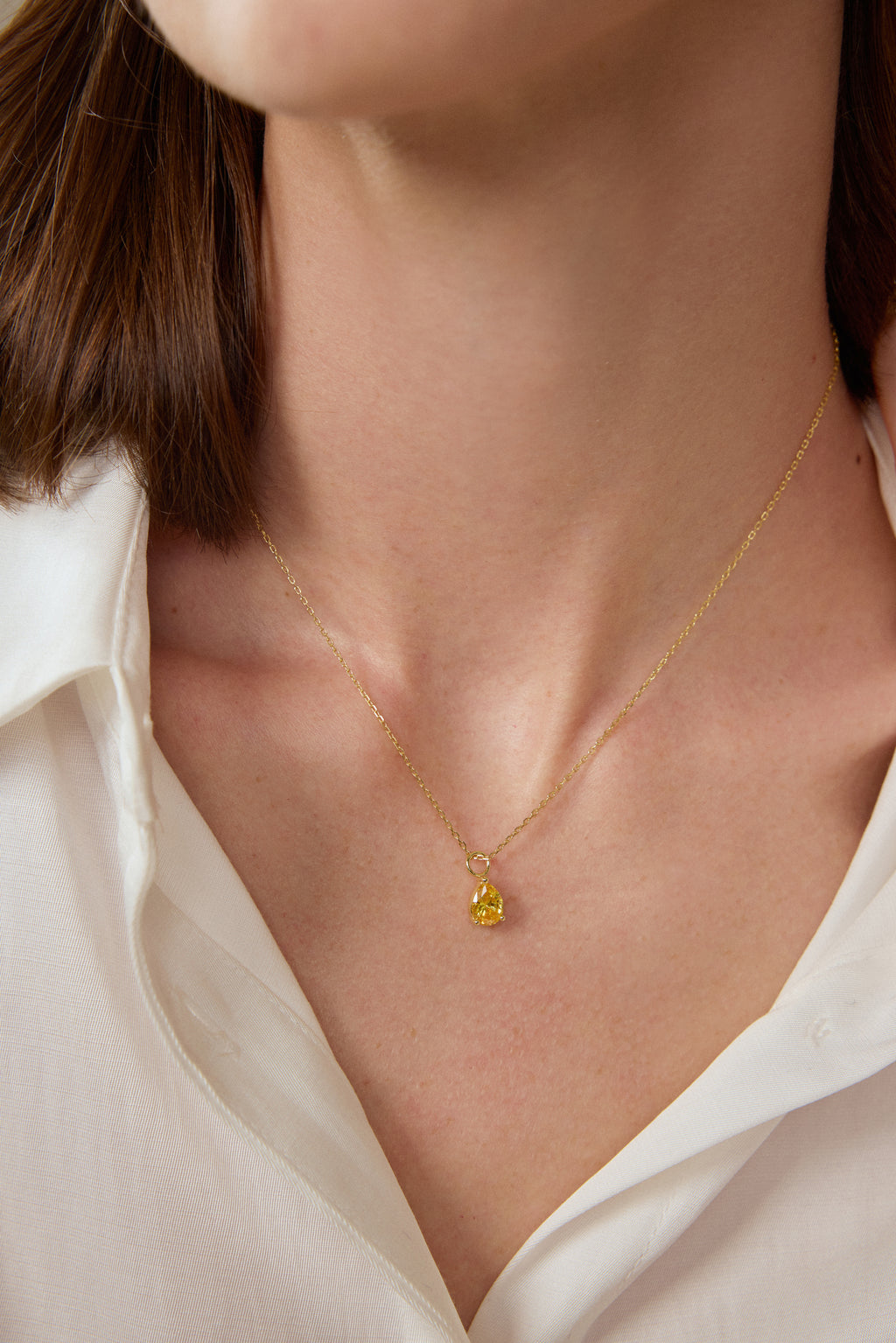 Model trägt einen tropfenförmigen Fancy Yellow Diamantanhänger aus 18K Gold mit 2,00 ct Labordiamant an einer feinen Goldkette