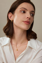 Model trägt einen tropfenförmigen Fancy Yellow Diamantanhänger aus 18K Gold mit 2,00 ct Labordiamant an einer feinen Goldkette