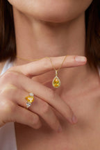 Detailaufnahme eines Fancy Yellow Diamantanhängers aus 18K Gold mit 3,50 ct Labordiamanten, gehalten am Finger und kombiniert mit passendem Diamantring