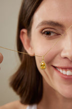Model hält einen Fancy Yellow Diamantanhänger aus 18K Gold mit 3,50 ct Labordiamanten vor das Gesicht