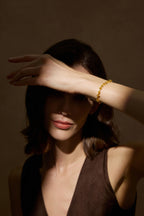 Model trägt ein Fancy Yellow Diamantarmband aus 18K Gold mit Labordiamanten in verschiedenen Schliffformen in einer stimmungsvollen Editorial-Aufnahme