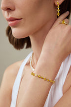 Model trägt ein Fancy Yellow Diamantarmband aus 18K Gold mit Labordiamanten in verschiedenen Schliffformen sowie passende Ohrringe und Ringe