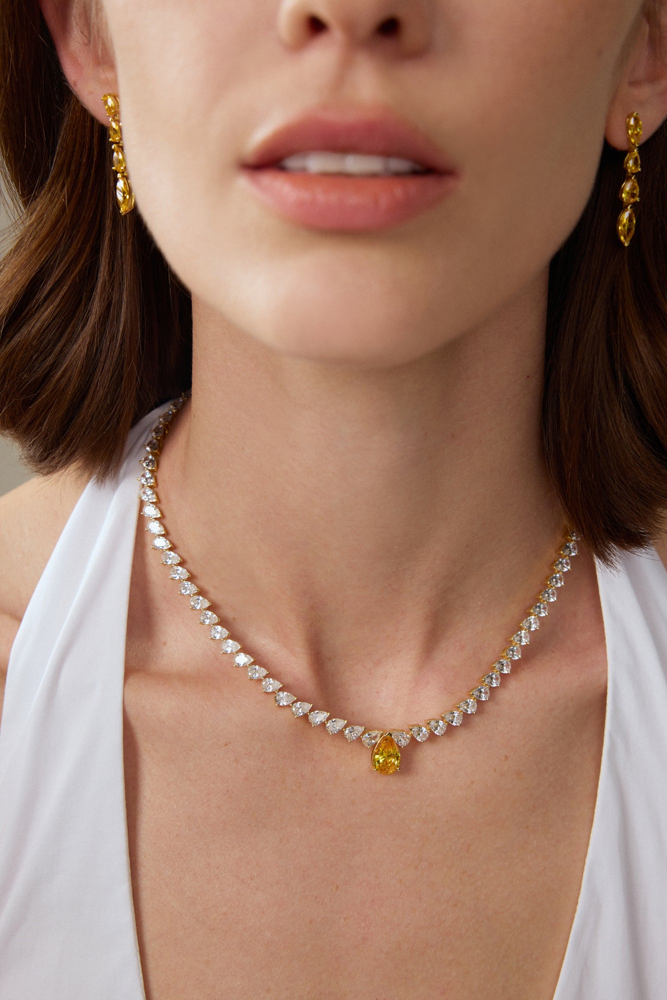 Model trägt ein Diamantcollier aus 18K Gold mit tropfenförmigen Labordiamanten und zentralem Fancy Yellow Diamanten