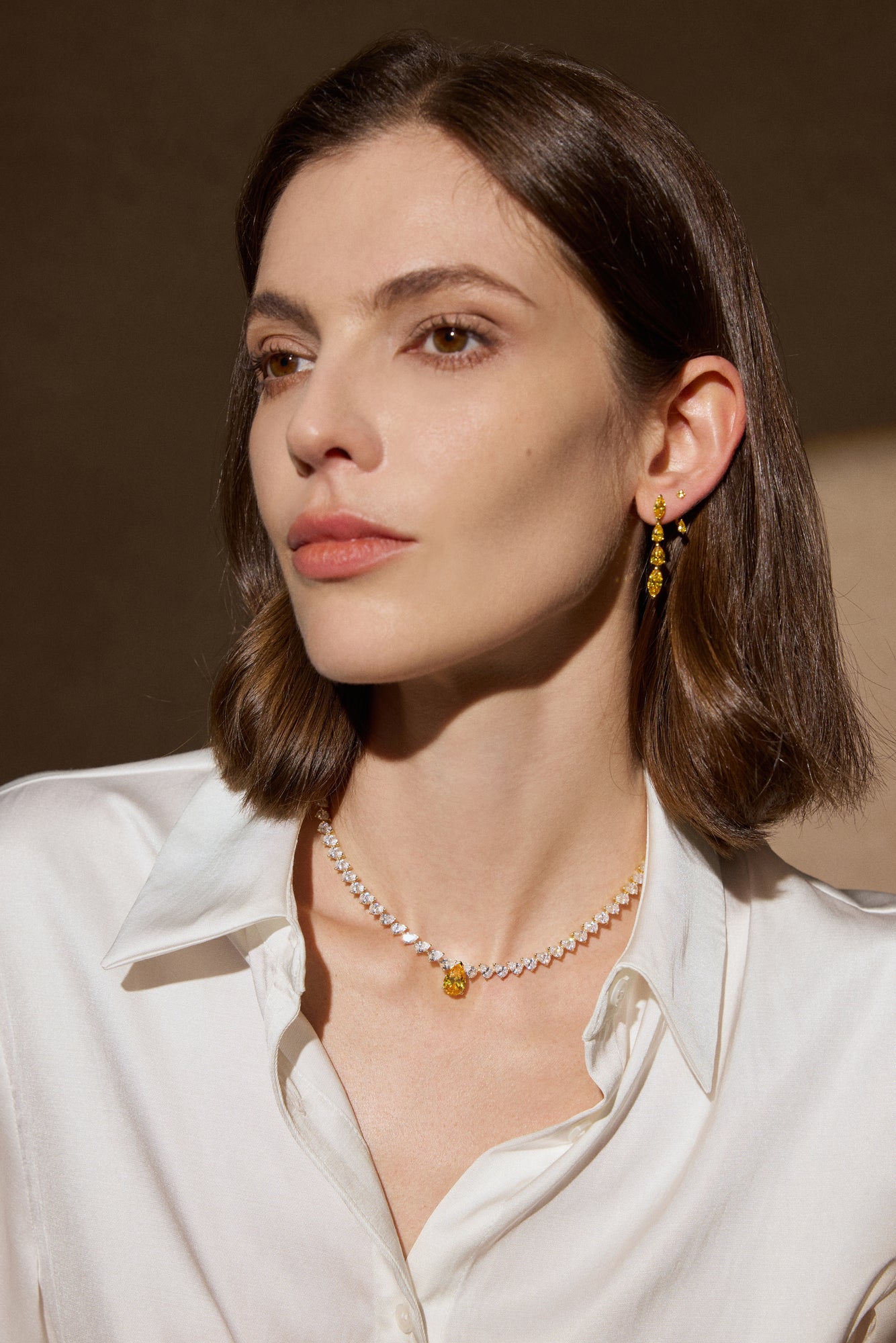 Model trägt ein Fancy Yellow Diamantcollier aus 18K Gold mit 34,00 ct Labordiamanten und passende Fancy Yellow Ohrhänger
