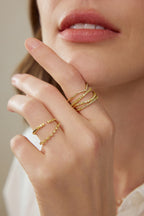 Model trägt einen V-förmigen Ring aus 18K Gold mit 0,35 ct Fancy Yellow Labordiamanten zusammen mit weiteren filigranen Diamantringen