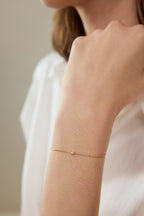 Filigranes Armband aus 18K Gelbgold mit gelbem Diamanten am Handgelenk getragen.