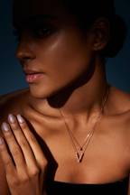 Model trägt eine zweireihige Diamantkette aus 18K Roségold mit diamantbesetztem V-Anhänger und quadratischem Diamantdetail im kontrastreichen Licht.