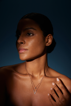 Model trägt eine zweireihige Diamantkette aus 18K Roségold mit diamantbesetztem V-Anhänger und quadratischem Diamantdetail im warmen Sonnenlicht.