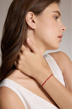 Model trägt ein rotes Armband aus veganem Leder mit 0,10 ct Labordiamant und Details aus 18K Gold