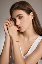 Model trägt ein rotes Armband aus veganem Leder mit 0,10 ct Labordiamant und Details aus 18K Gold.