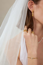Skulpturaler Crossover Ring aus massivem 18K Gold als Teil eines eleganten Brautschmuck Stylings getragen.