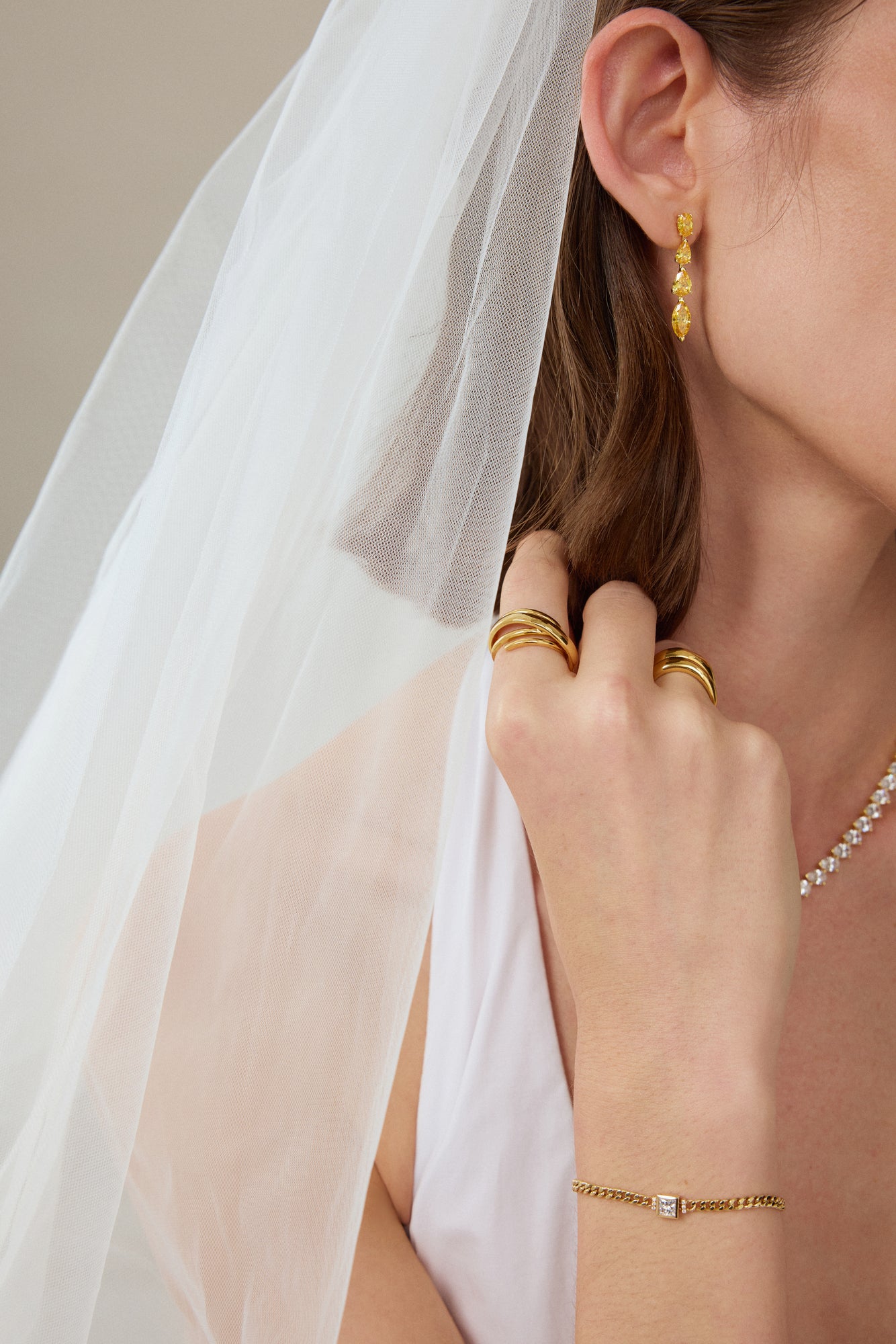 Skulpturaler Crossover Ring aus massivem 18K Gold als Teil eines eleganten Brautschmuck Stylings getragen.
