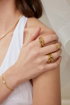 Skulpturaler Ring aus massivem 18K Gold als Teil eines eleganten Ring Stylings am Finger getragen.