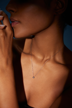 Model trägt eine Solitär-Diamantkette aus 18K Weißgold mit rundem Labordiamanten in Zargenfassung im kontrastreichen Licht.