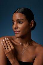 Model trägt drei Solitär-Diamantketten aus 18K Weißgold mit runden Labordiamanten in unterschiedlichen Größen sowie passenden Diamantschmuck.