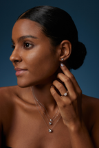 Model trägt drei Solitär-Diamantketten aus 18K Weißgold mit runden Labordiamanten in unterschiedlichen Größen sowie passende Diamant-Ohrstecker und einen Solitärring.